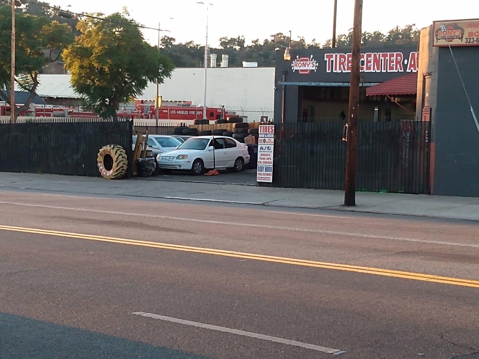 Rony's Tire Center building with parking lot and cars outside, located in a commercial area.
